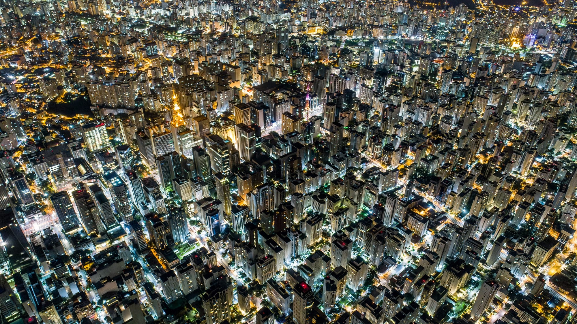 Bacurau Noturno, fotografia fine art de Bruno Boni. Fotografia aérea noturna, no estilo punk tech, tecnicamente desafiadora. Geometria retangular das quadras e prédios…