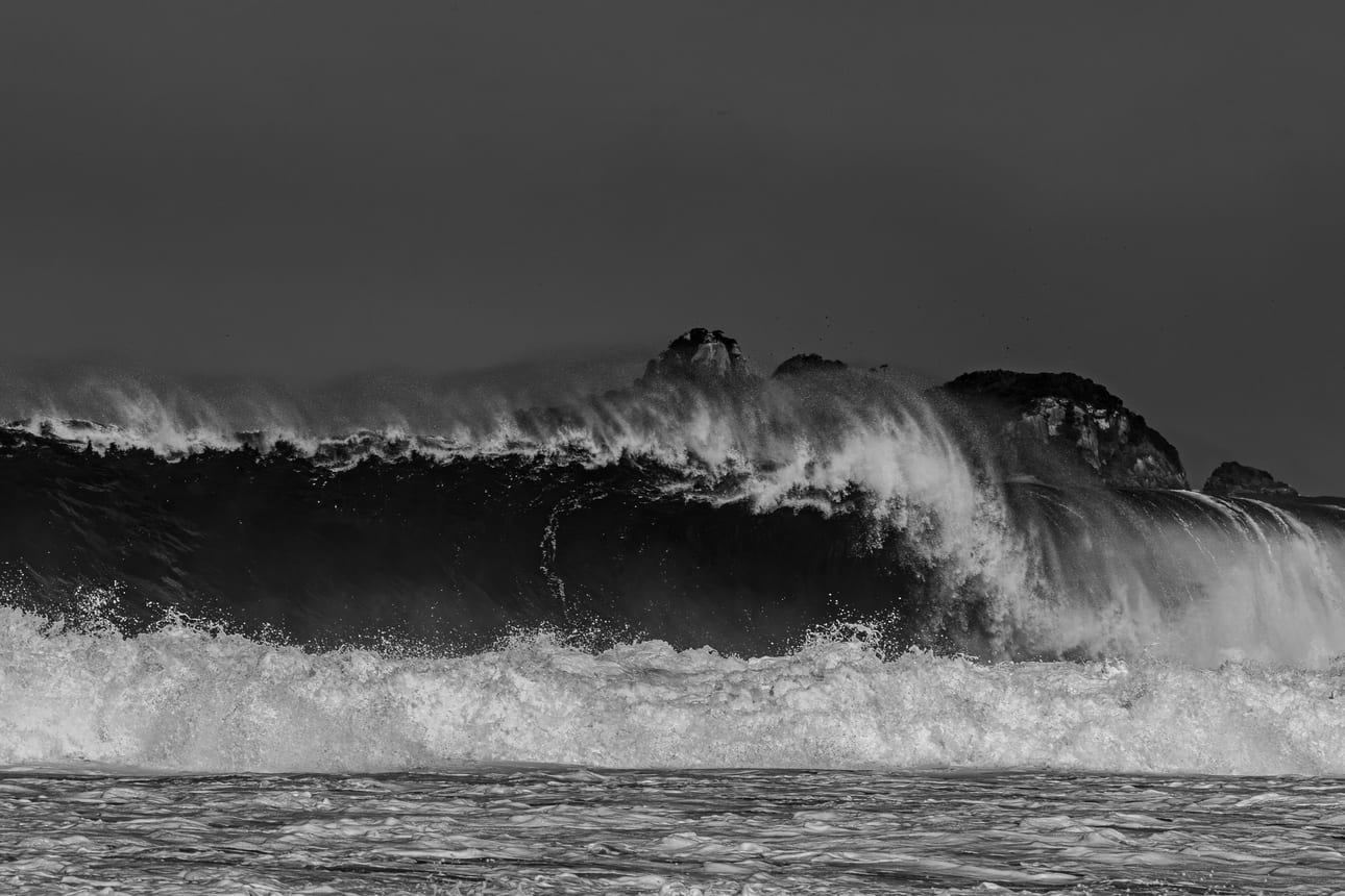 Encontro Explosivo 4, fotografia fine art de Bruno Boni. Uma muralha de água escura avança sobre a costa de São Conrado enquanto o vento arranca da crista véus de borrifo…