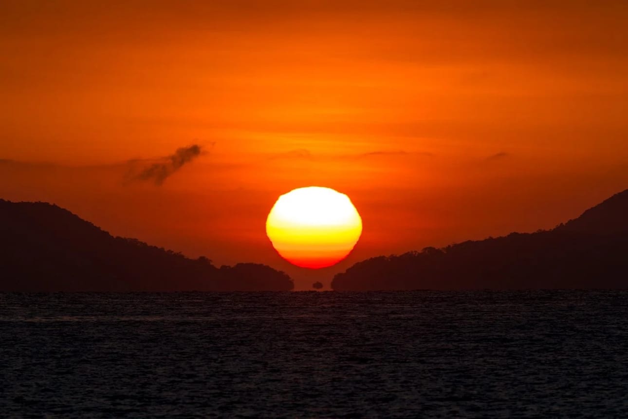 Fata Morgana, fine art photograph by Bruno Boni. The sun rises over the Lagoa Azul channel, on Ilha Grande, perfectly aligned with the corridor between Ilha dos Macacos…