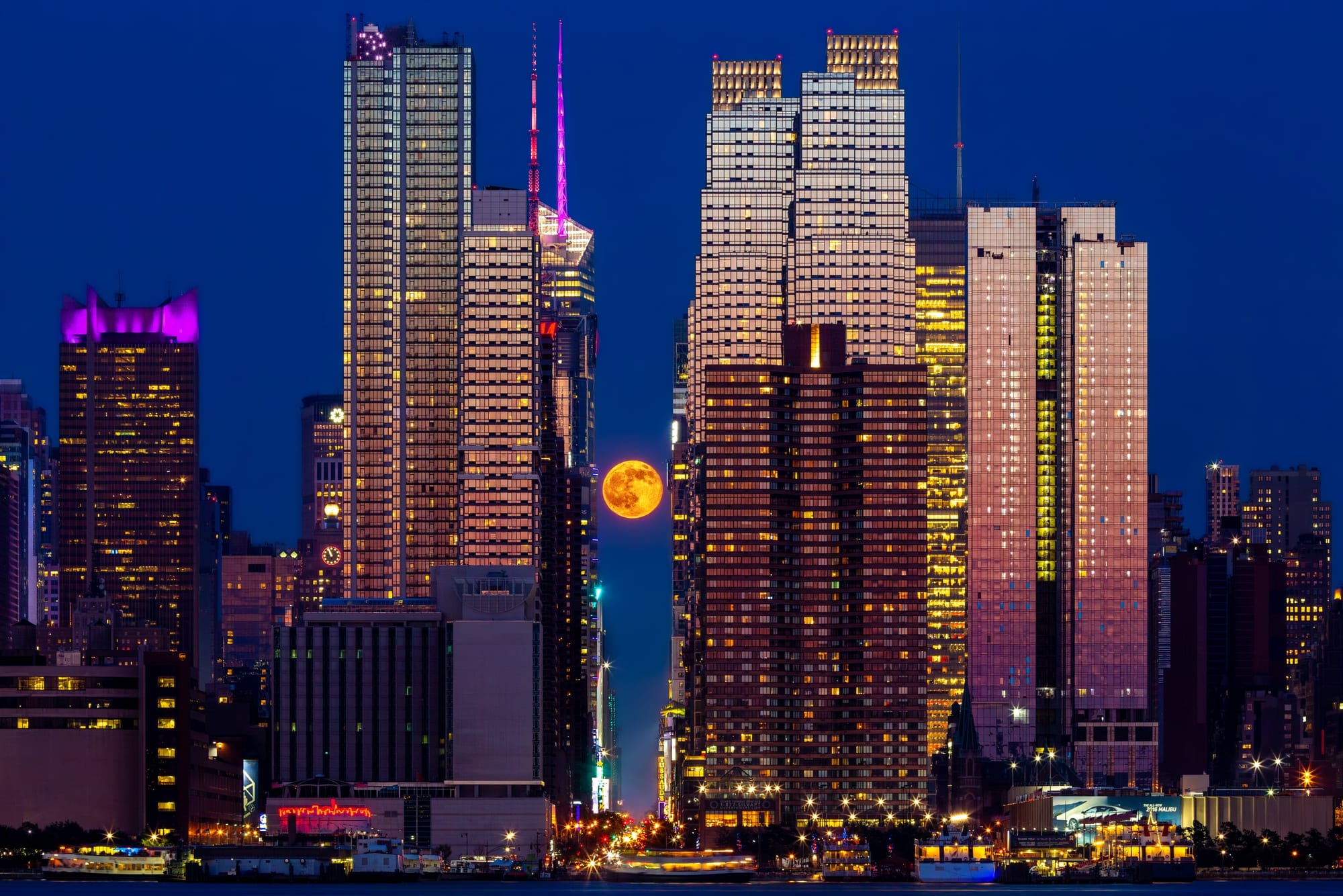 Moonhattanhenge, fine art photograph by Bruno Boni. Twice a year, photographers jostle elbow to elbow for the Manhattanhenge, the sunset aligned with the streets of…