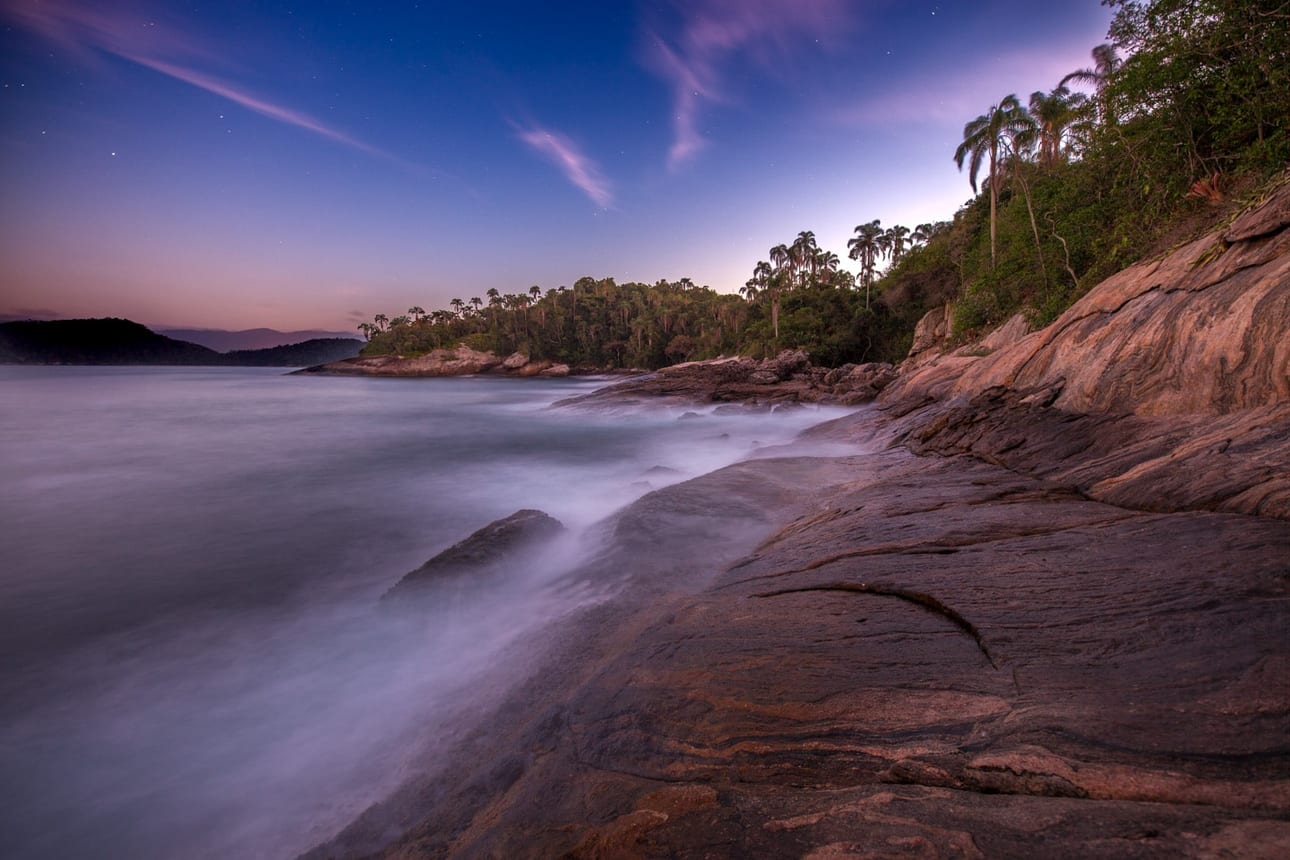 Ponta da Jurubaíba, fotografia fine art de Bruno Boni. Longa exposição registrada no crepúsculo na Ponta da Jurubaíba, perto da Praia do Dentista, em Angra dos Reis. O mar se…