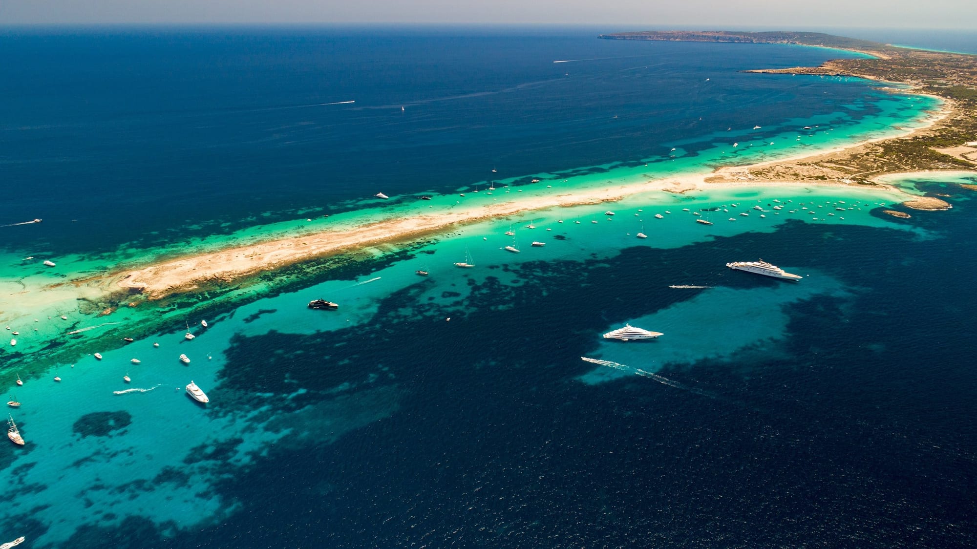 Azul Illetes, fotografia fine art de Bruno Boni. Vista aérea das águas cristalinas e vibrantes da praia de Ses Illetes, em Formentera. A imagem revela a diversidade…